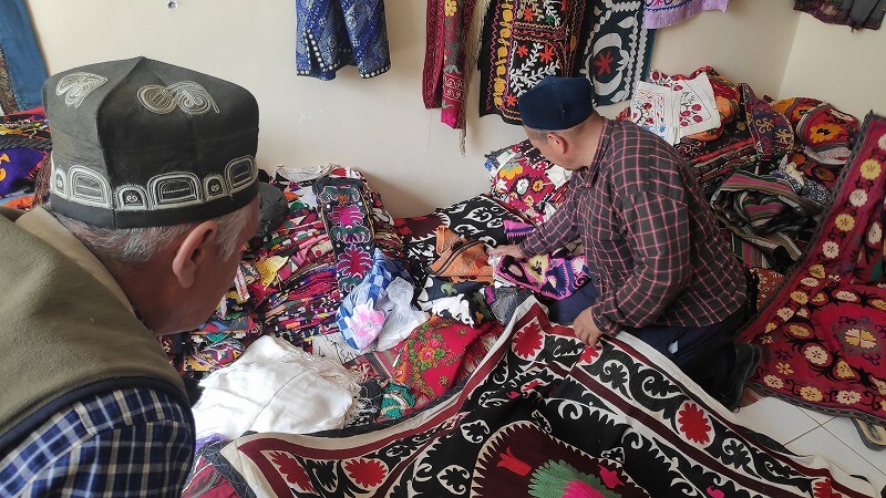 ウズベキスタン、ウルグットのスザニを見せるおじさん